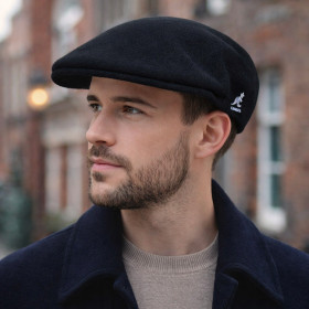 Homme portant une casquette plate Kangol Wool 504 noire en laine vierge