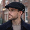 Homme portant une casquette plate Kangol Wool 504 noire en laine vierge