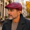 Homme portant une casquette Broker en cuir d’agneau bordeaux dans un style urbain élégant