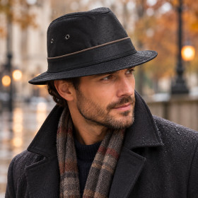 Chapeau Traveller noir imperméable porté par un homme sous la pluie